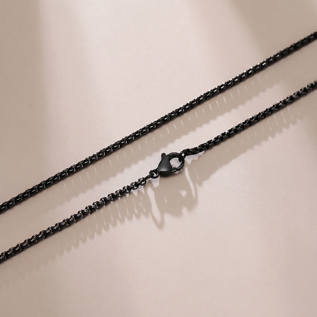 Black chain necklace on a beige background