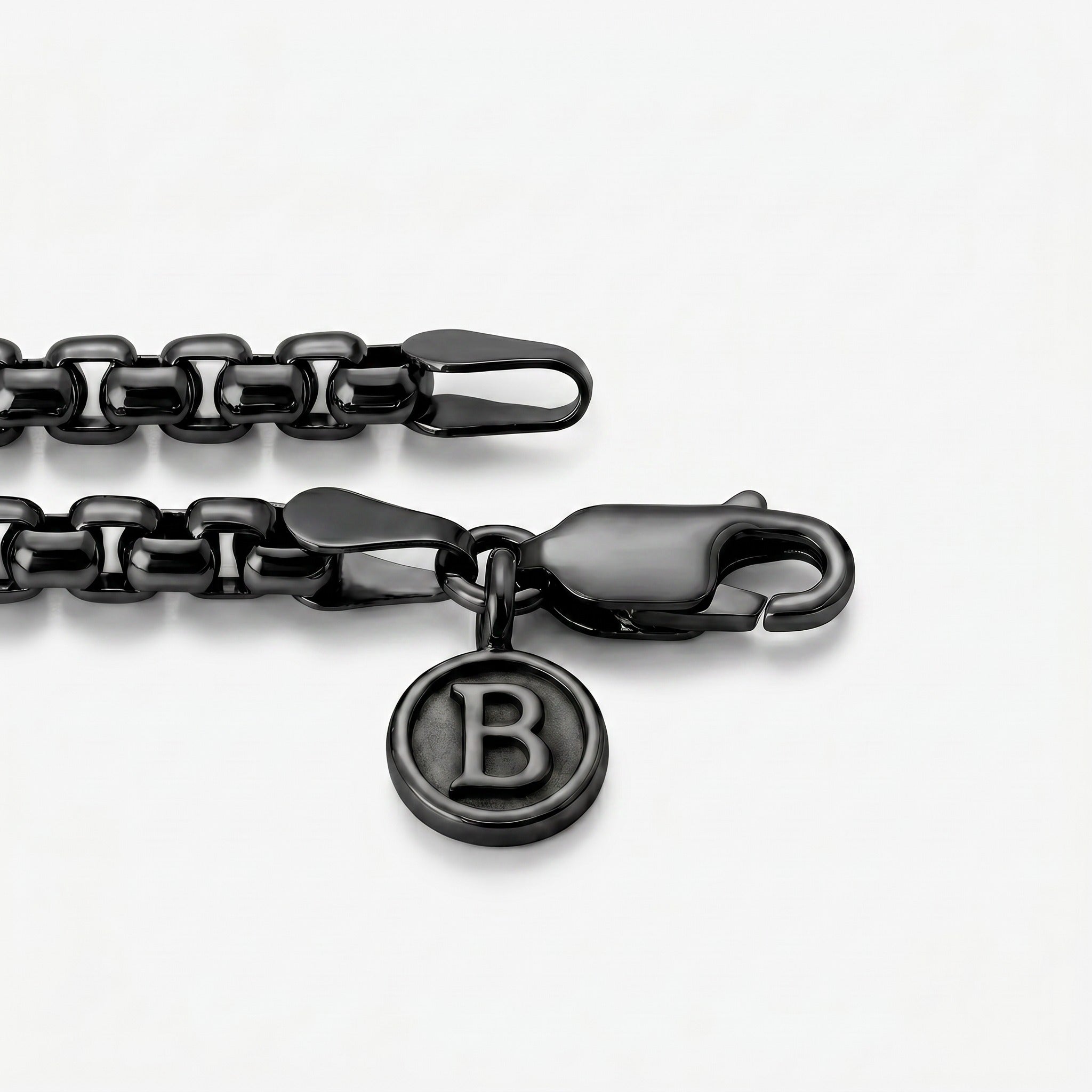 Black chain bracelet with a clasp and 'B'  logo charm on a white background