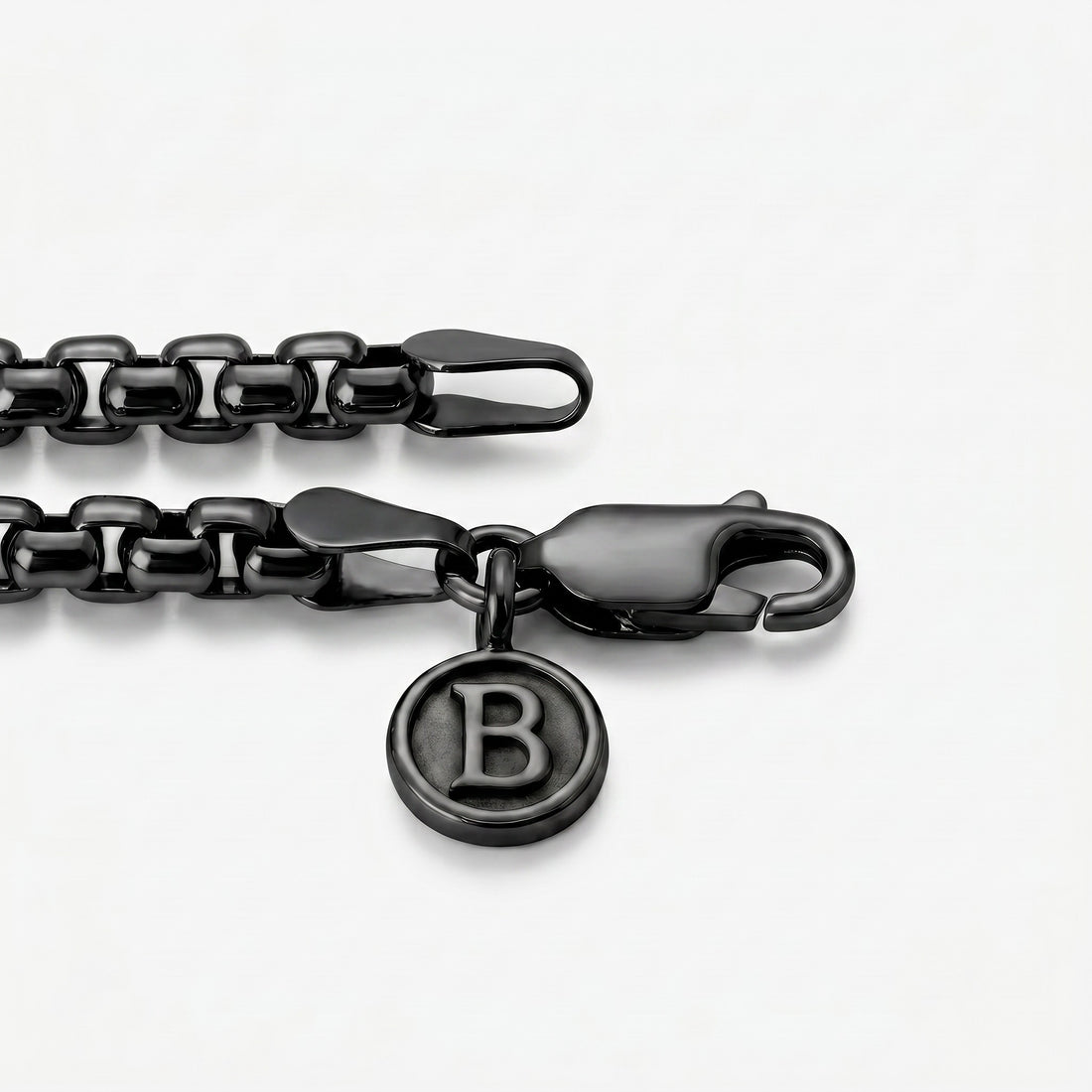 Black chain bracelet with a clasp and 'B'  logo charm on a white background