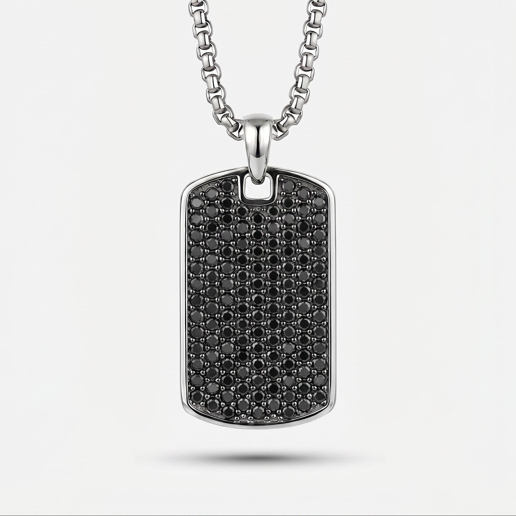 Silver necklace with a black diamond-studded pendant on a white background