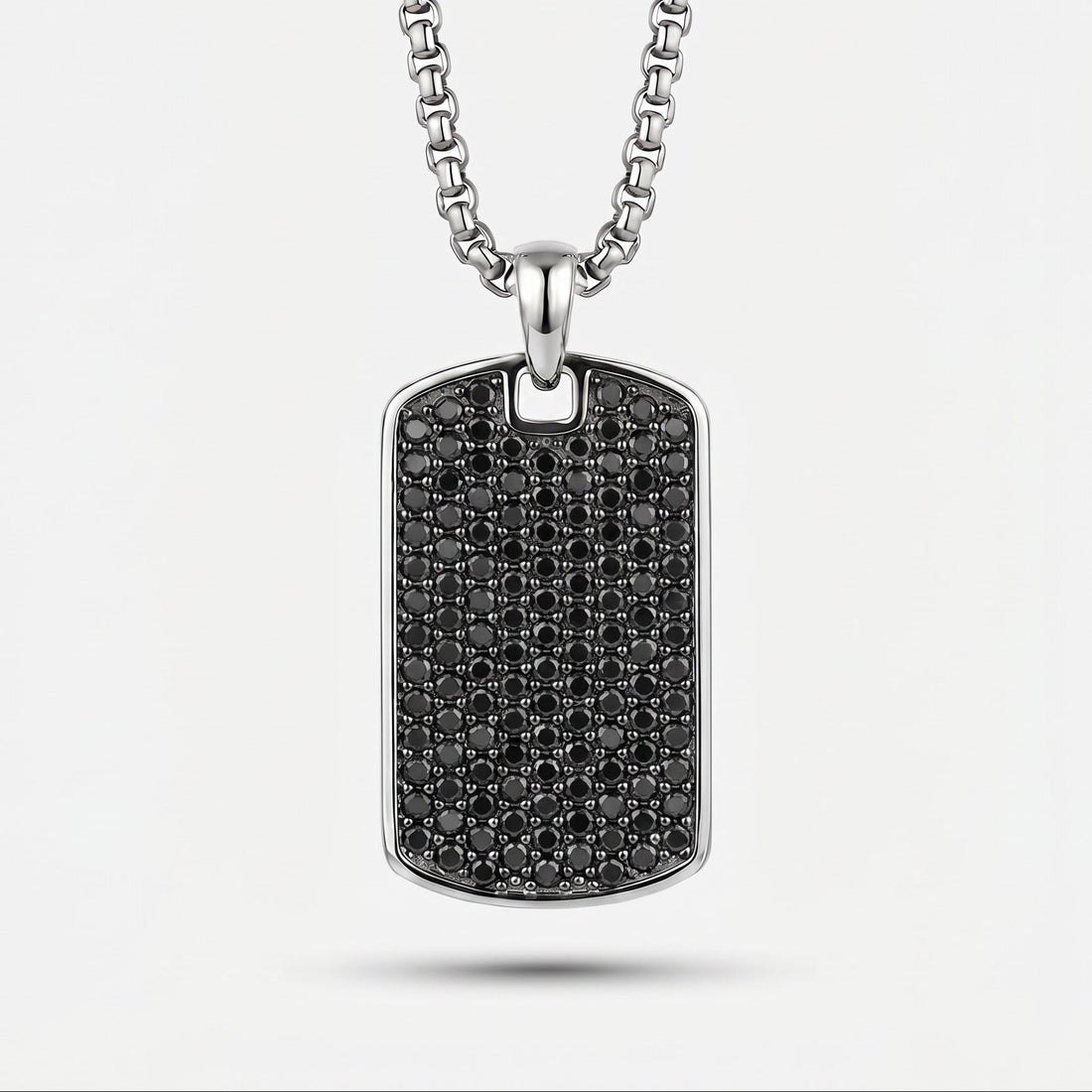 Silver necklace with a black diamond-studded pendant on a white background