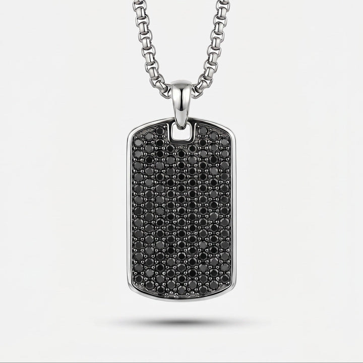 Silver necklace with a black diamond-studded pendant on a white background