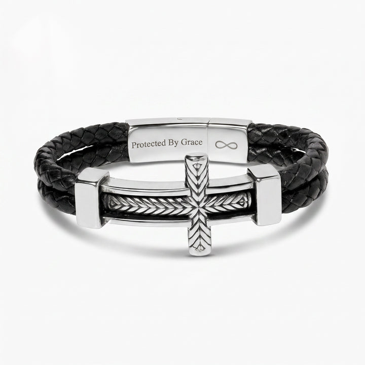 Black leather bracelet with silver clasp and cross design on a white background