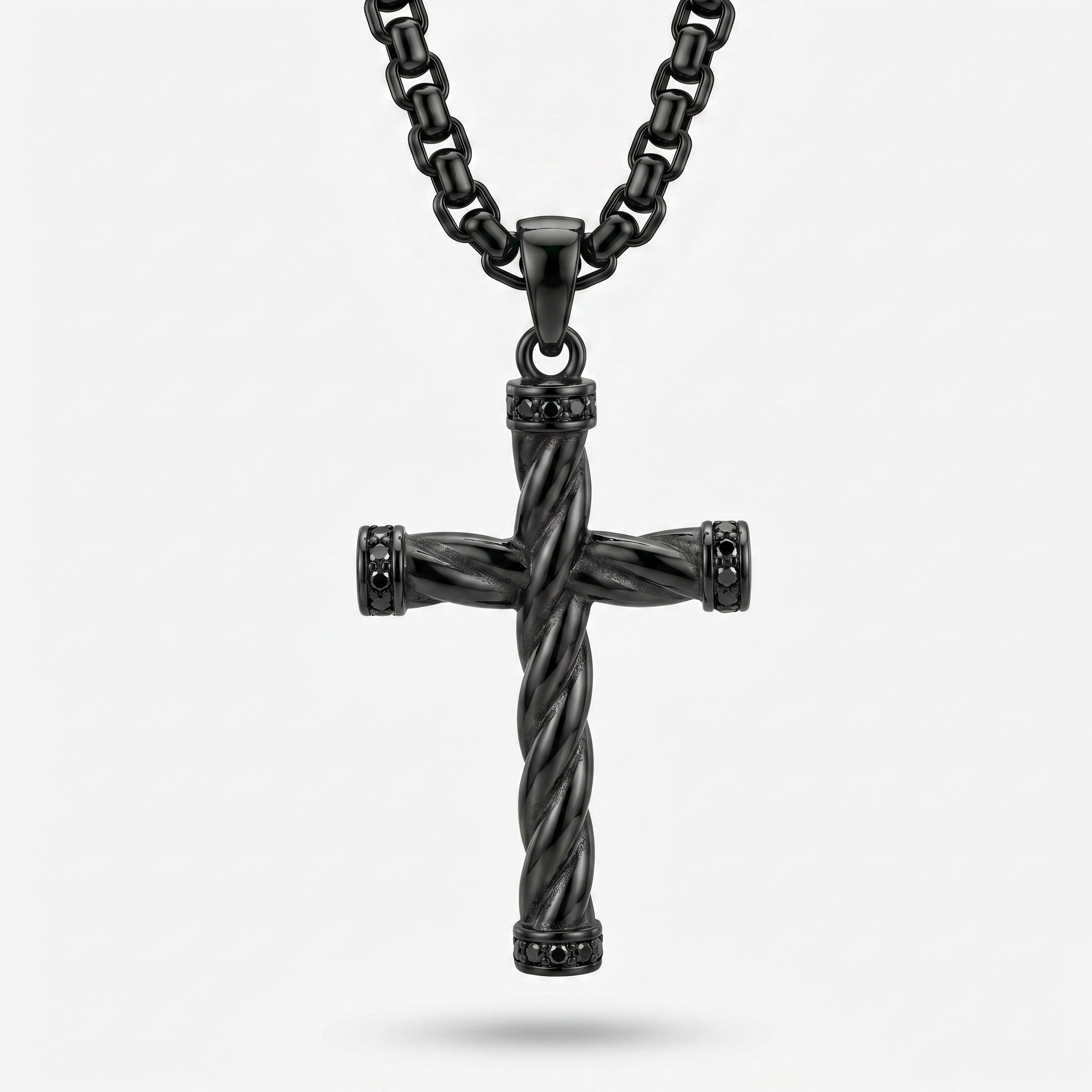 Black twisted cross pendant on a chain against a white background