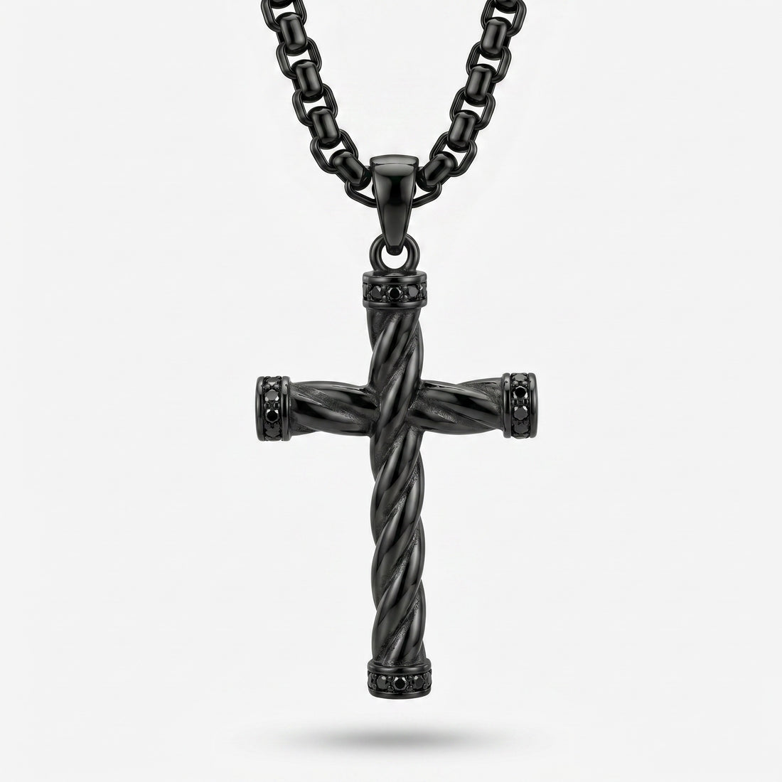 Black twisted cross pendant on a chain against a white background
