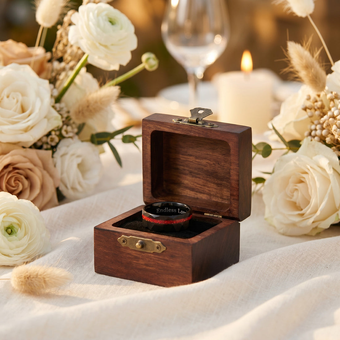 Wooden ring box with a ring on a table with flowers and candles