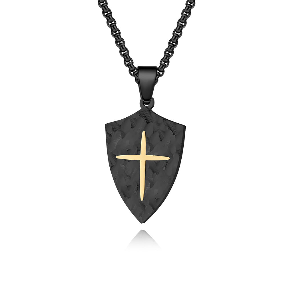 Black shield-shaped pendant with a gold cross on a black chain against a white background