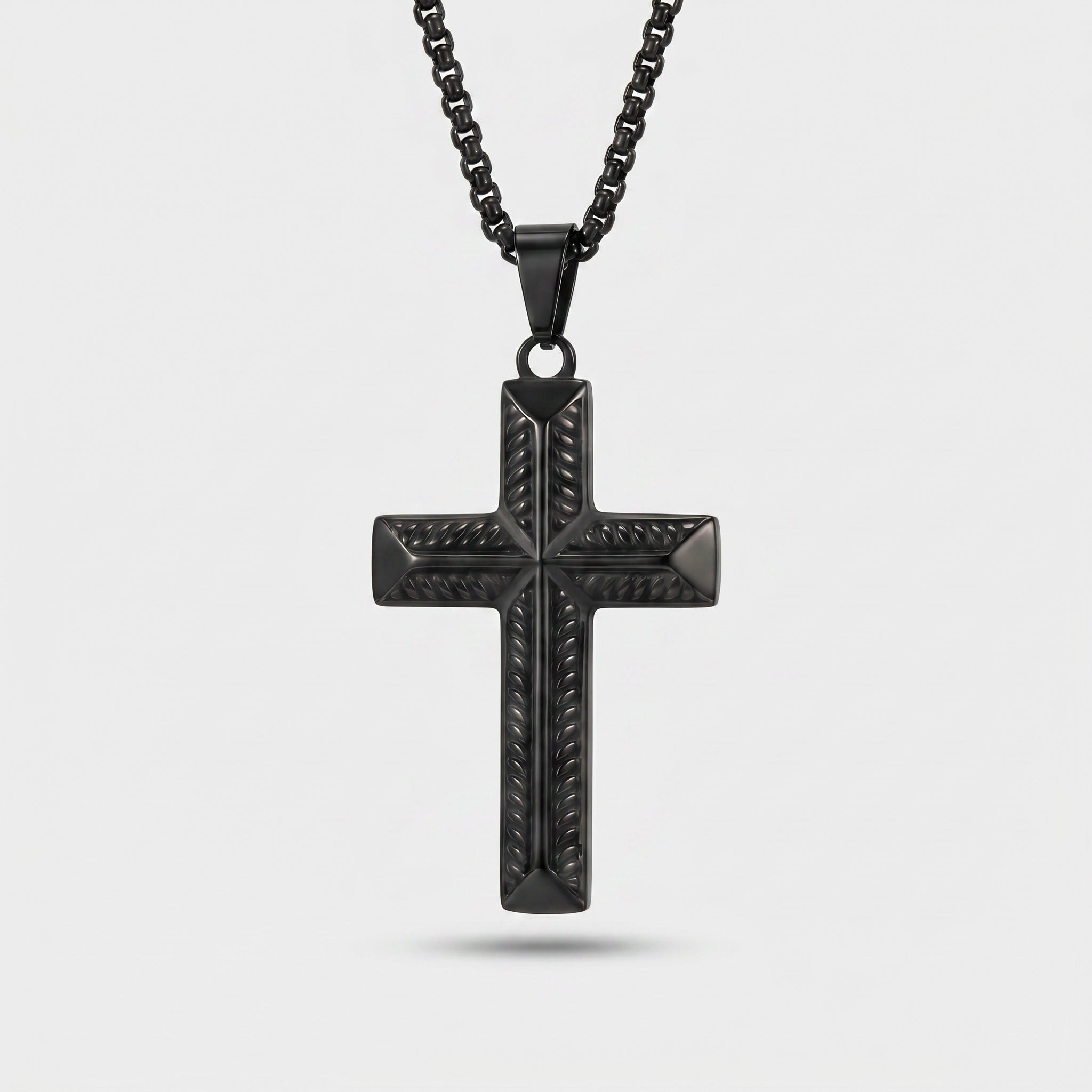 Black cross pendant necklace on a light gray background