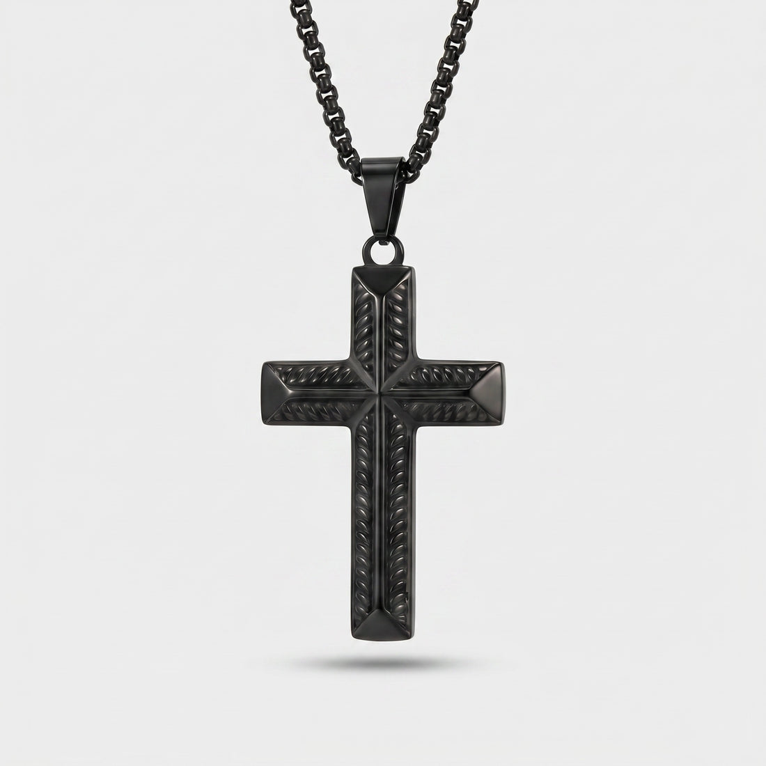 Black cross pendant necklace on a light gray background