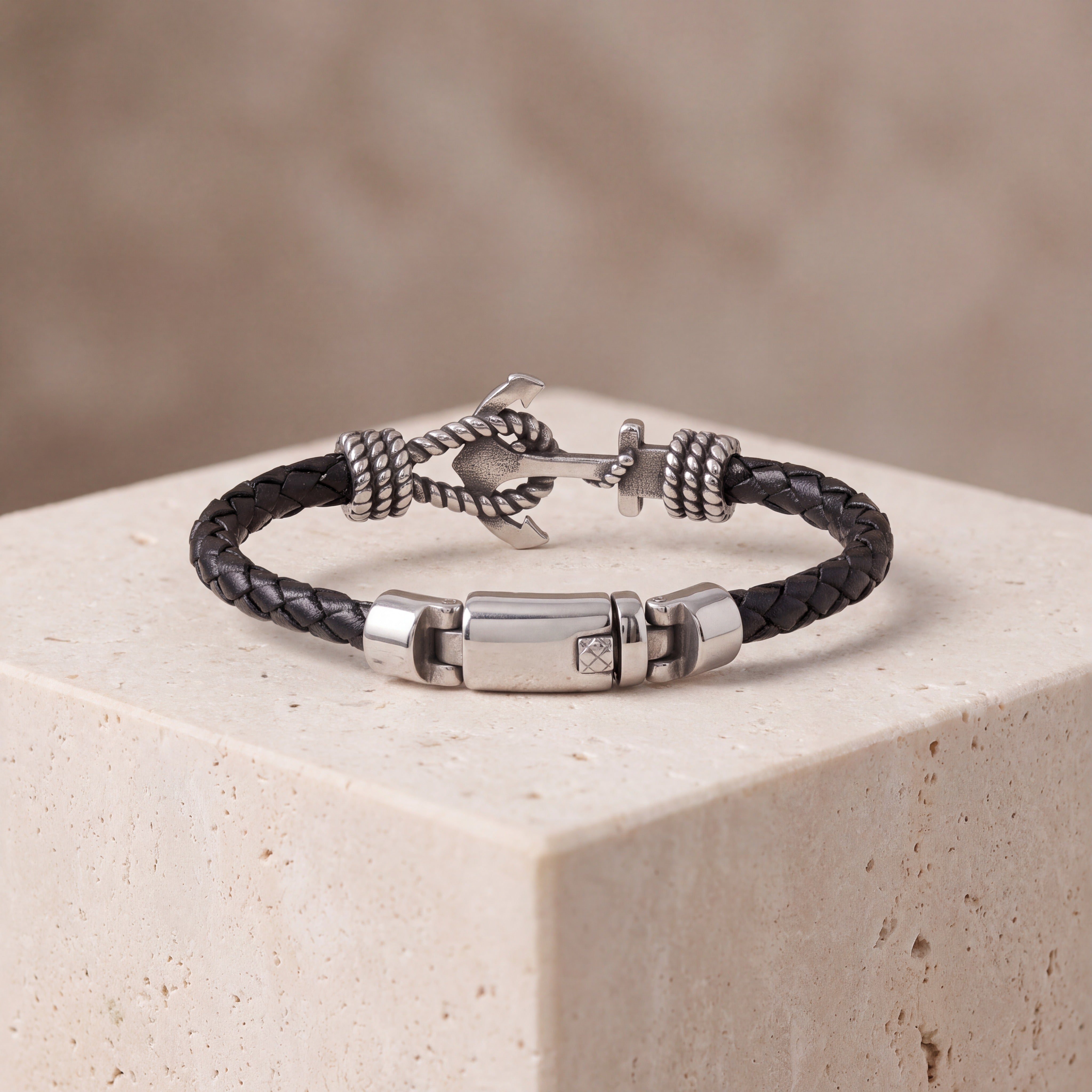  Engraved anchor bracelet resting on stone, showing the 8mm braided leather band