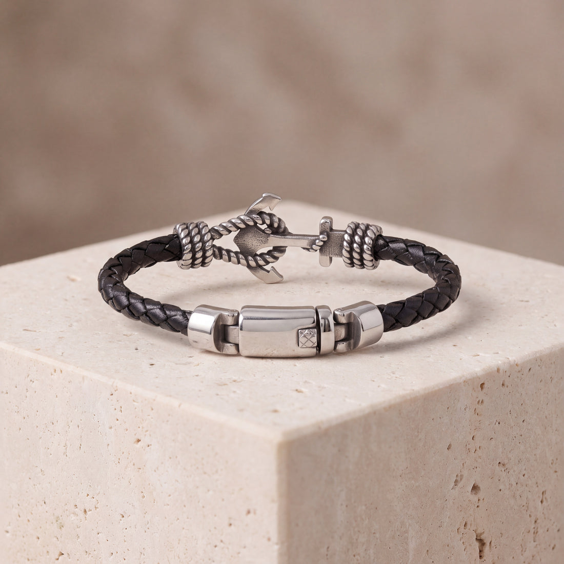  Engraved anchor bracelet resting on stone, showing the 8mm braided leather band