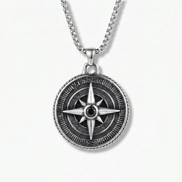 Silver compass pendant necklace on a white background