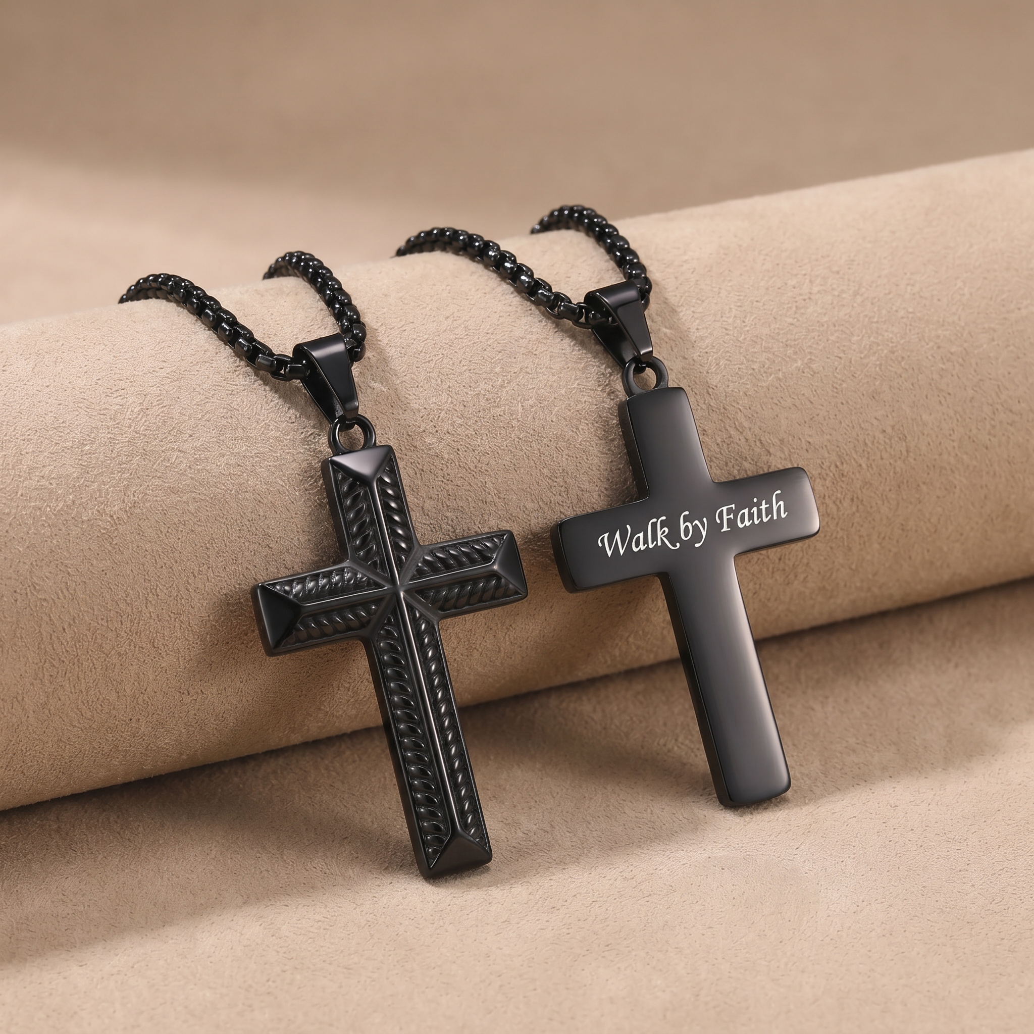 Two black cross necklaces on a beige surface