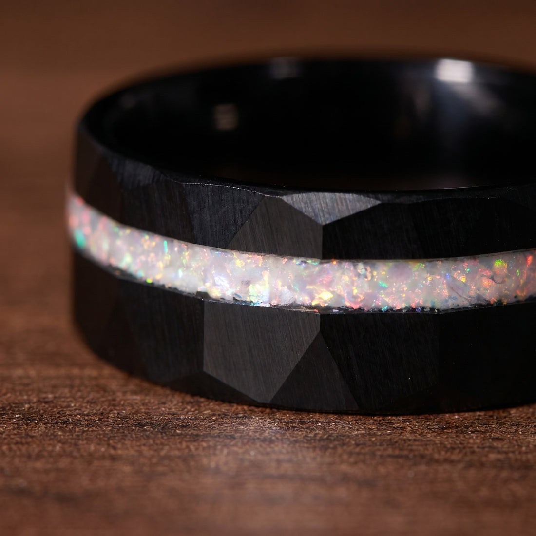 Black ring with a glittery band on a brown background