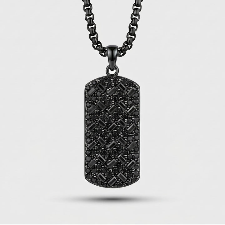 Black textured dog tag pendant on a chain against a light gray background