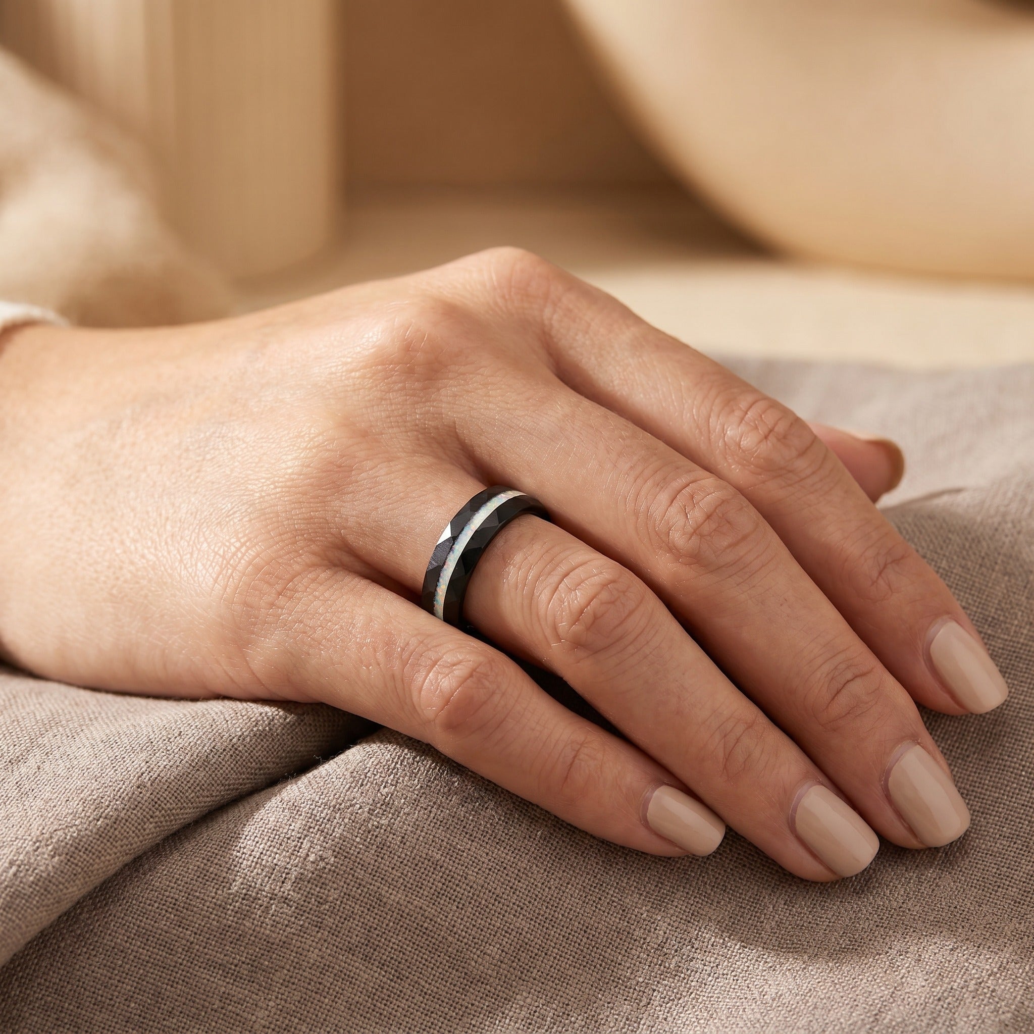 Hand wearing a ring on a soft fabric background