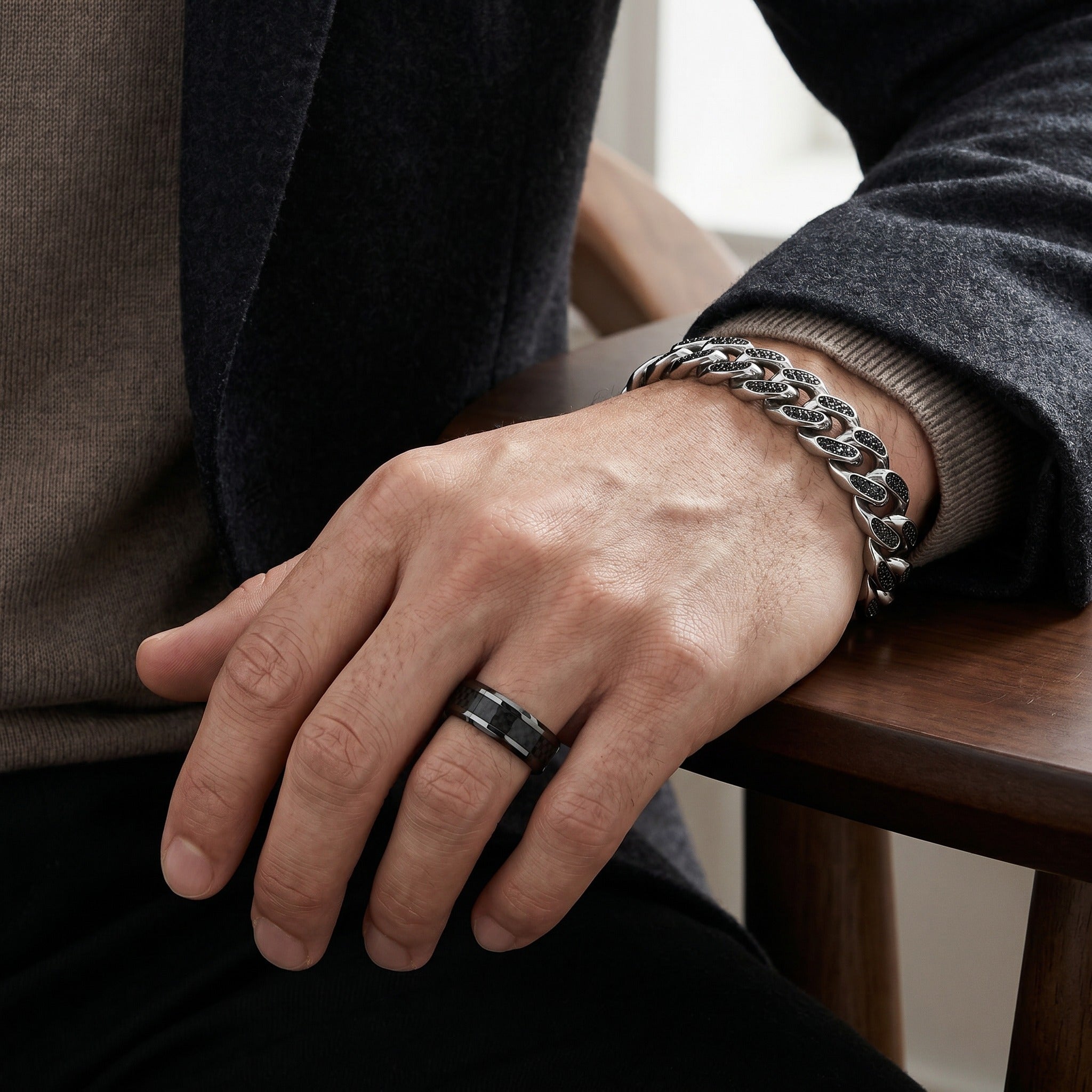 Hand with a ring and bracelet on a wooden surface