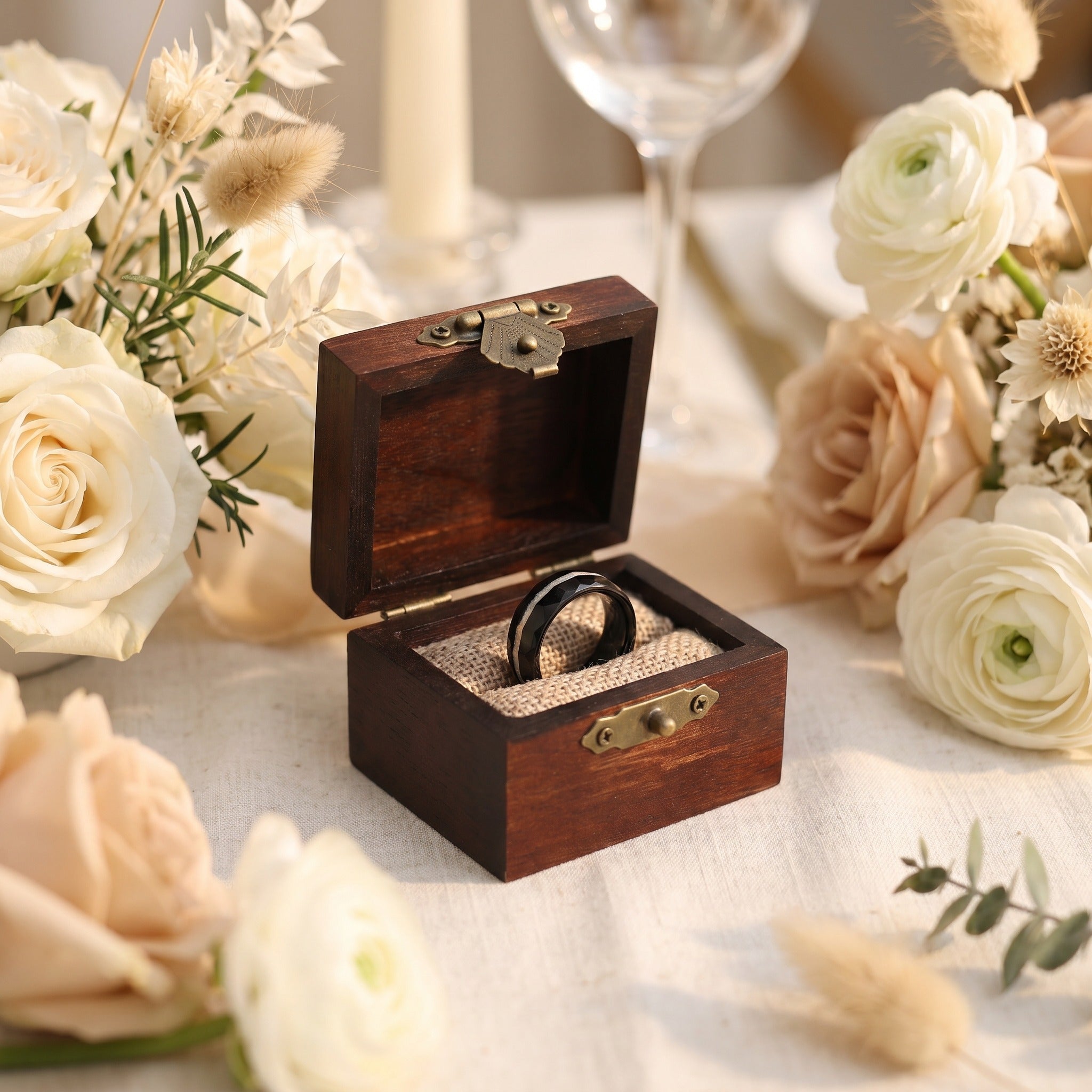 Wooden ring box with rings on a table surrounded by flowers