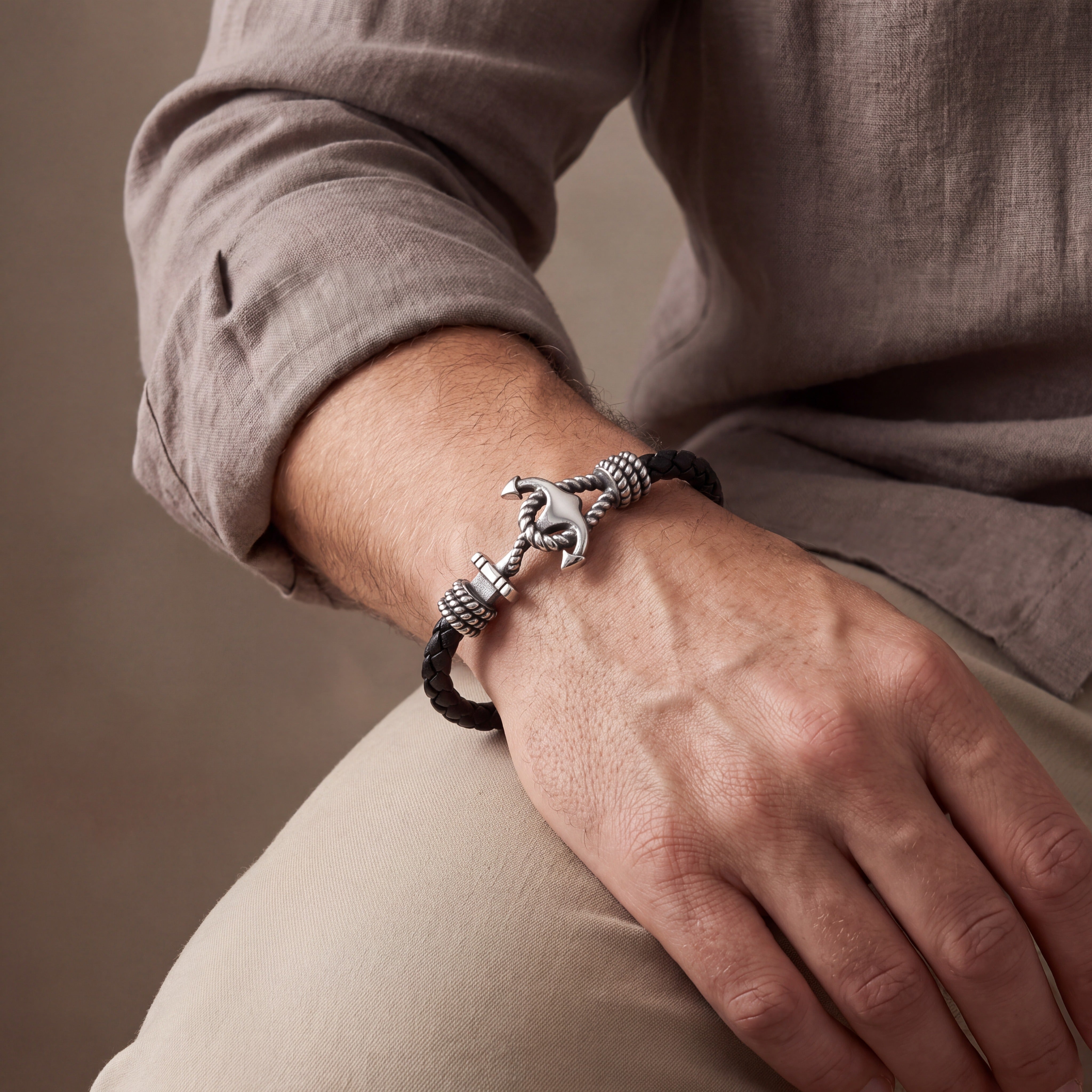 Man wearing The Mooring black leather anchor bracelet with a white linen shirt