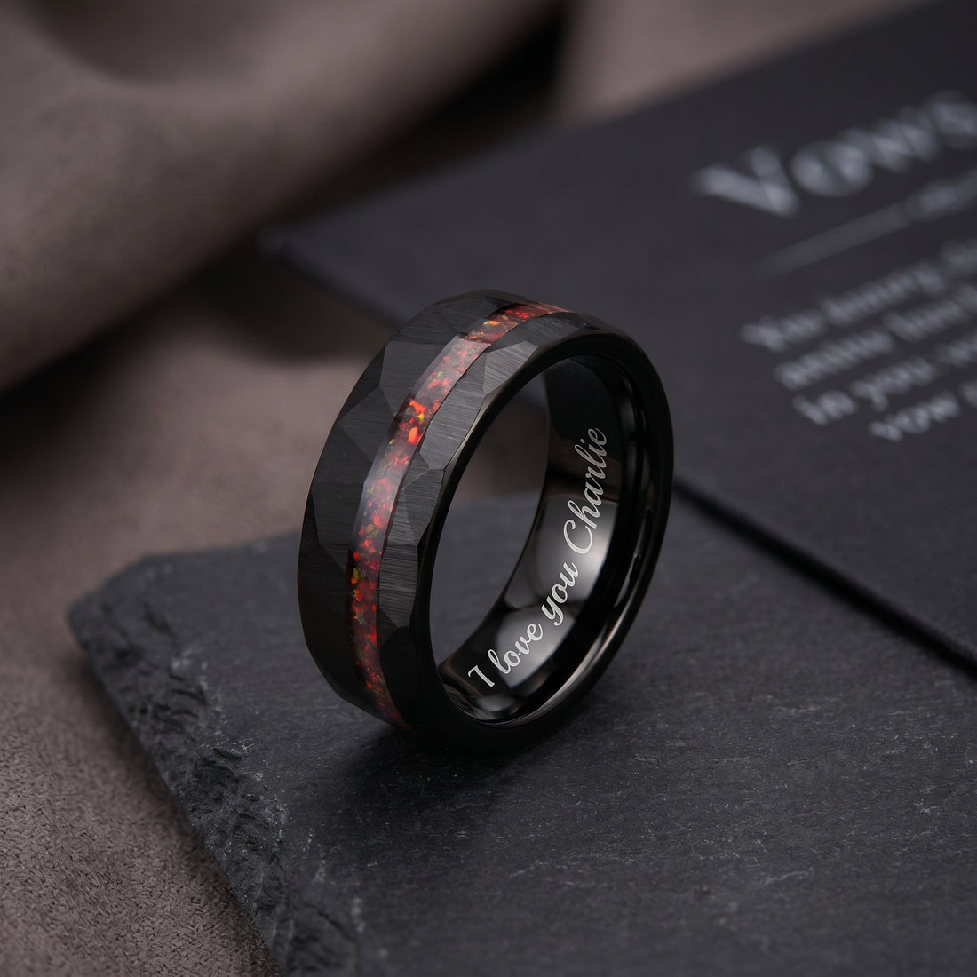 Black ring with red inlay on a dark surface