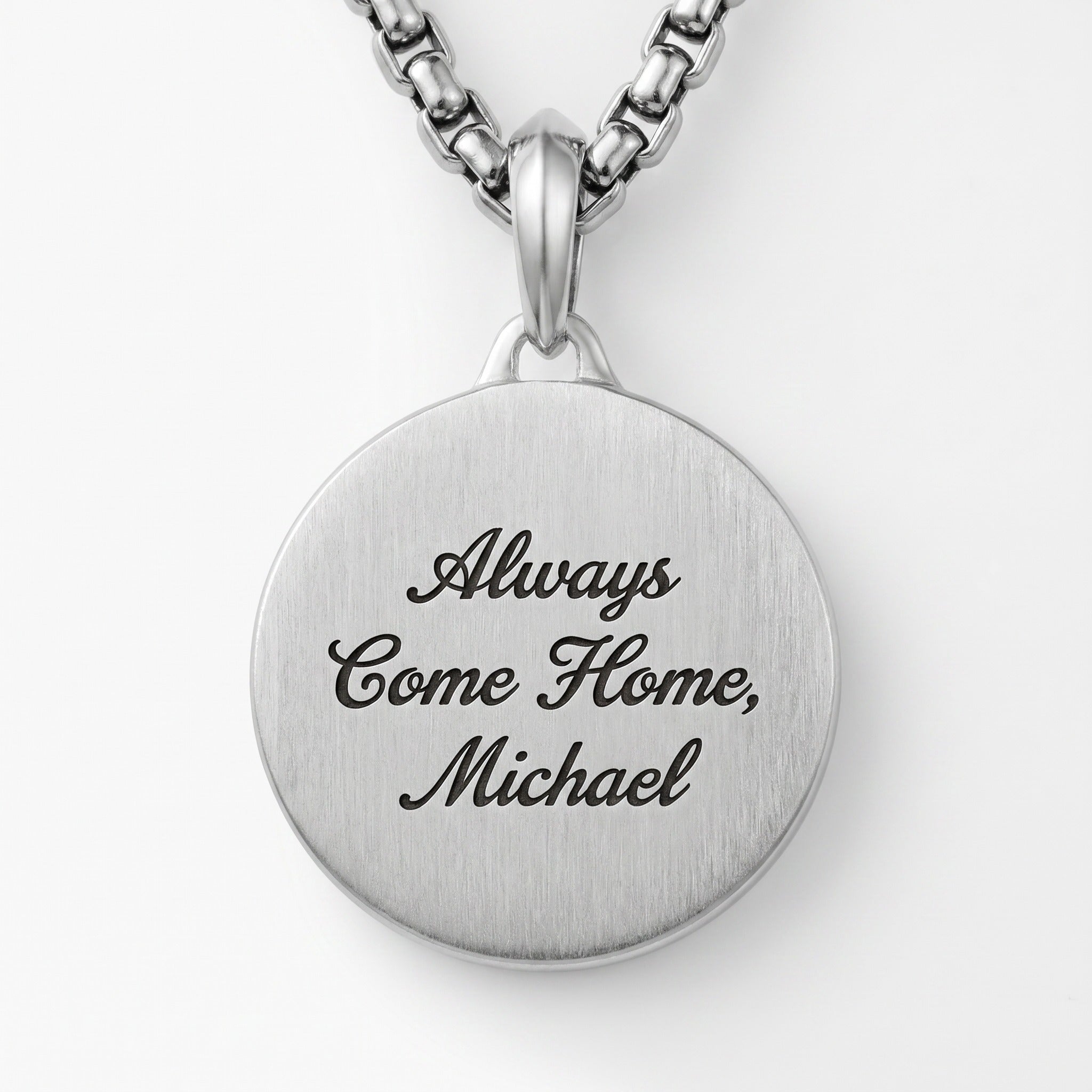 Silver pendant necklace with engraved text on a white background
